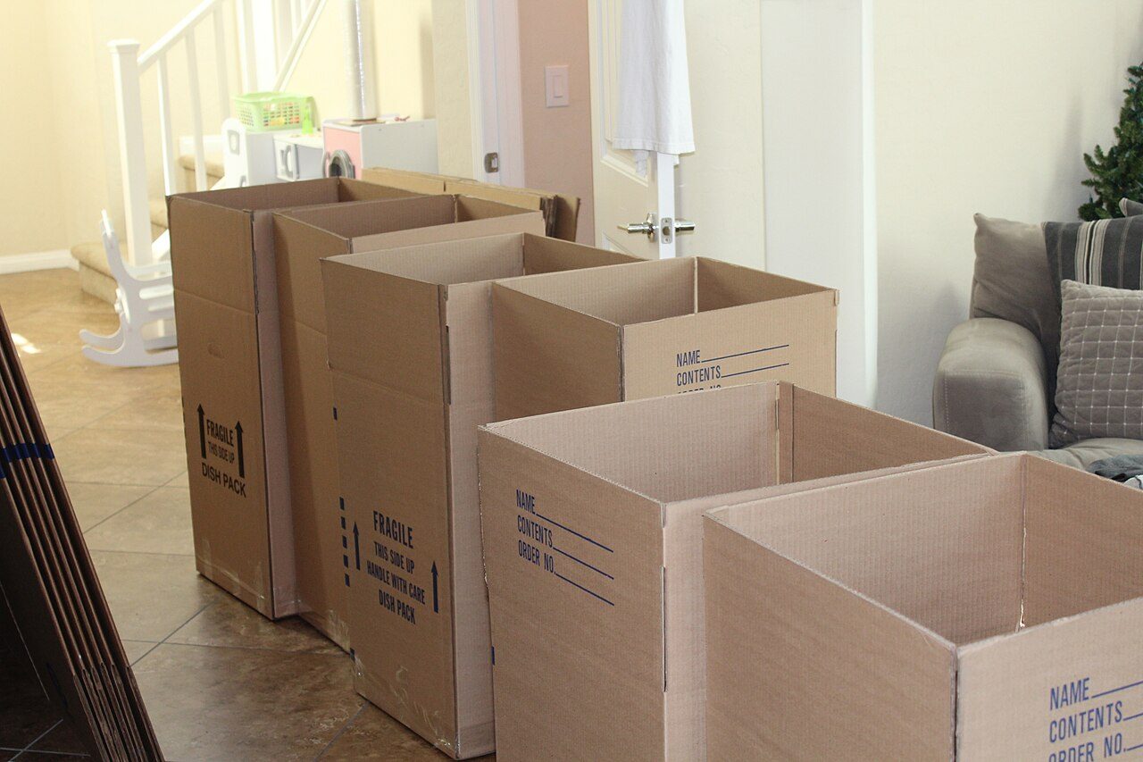 Stacked cardboard moving boxes in a hallway, ready for a household relocation