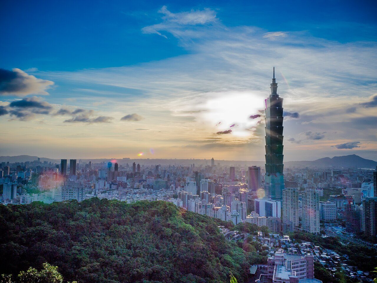 Taipei skyline at sunset, with Taipei 101 rising above the city basin